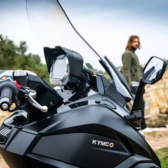 Scooter Kymco CV3 en virage sur une route de campagne