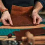 Skilled leather manufacture worker cutting some samples