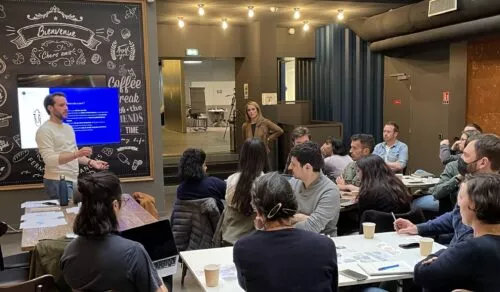 Atelier avec deux animateurs, Alizée et Damien, devant un public assis autour de tables